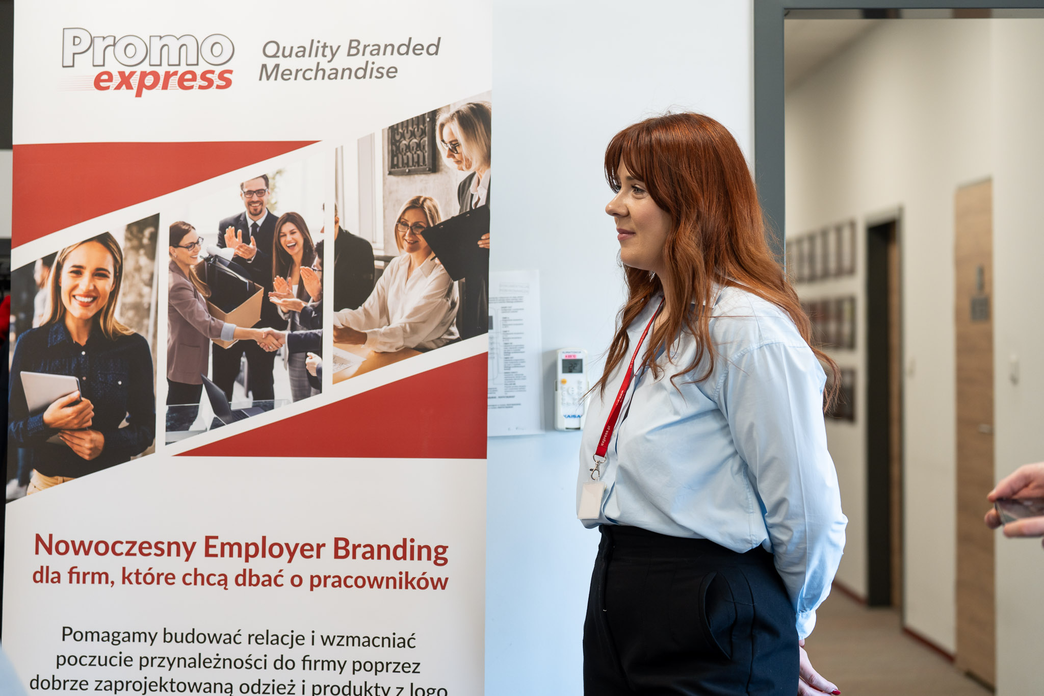 Uczestniczka stojąca obok baneru &bdquo;PromoExpress &ndash; Employer Branding&rdquo;.