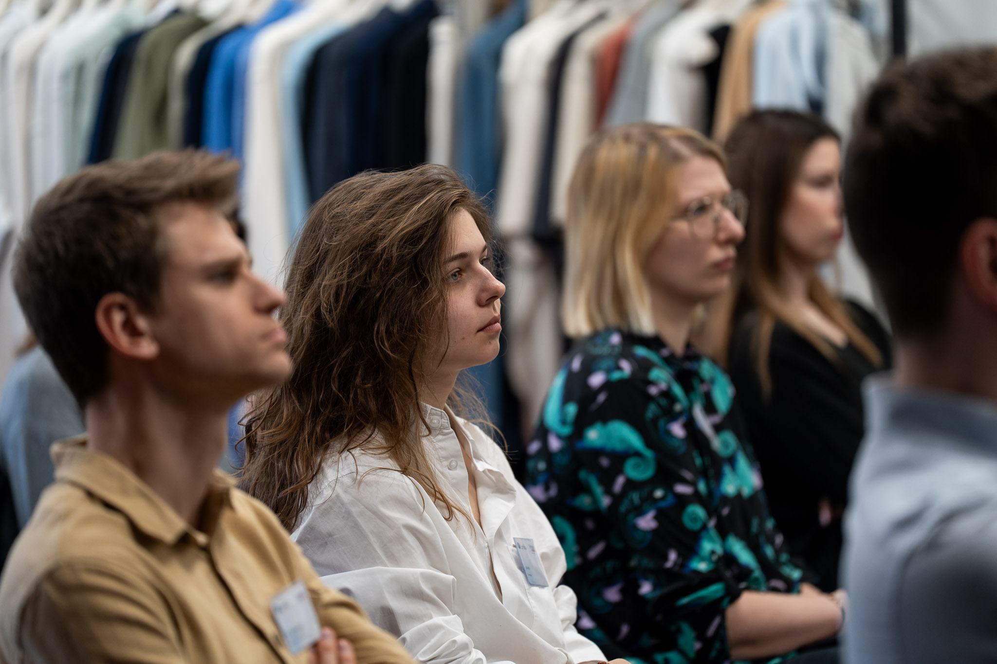 Zbliżenie na profil uczestnika słuchającego wystąpienia w skupieniu.