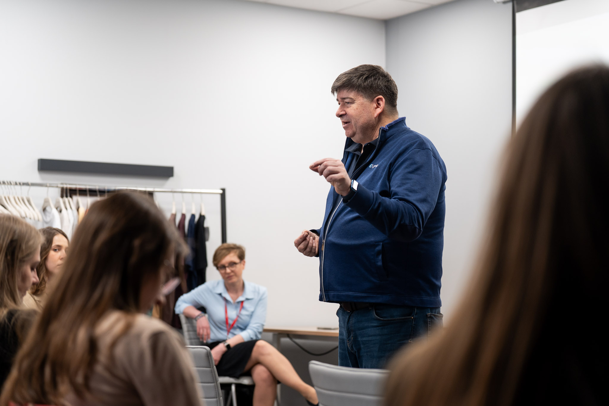 Prelegent w ciemnej bluzie tłumaczący zagadnienia liderom.