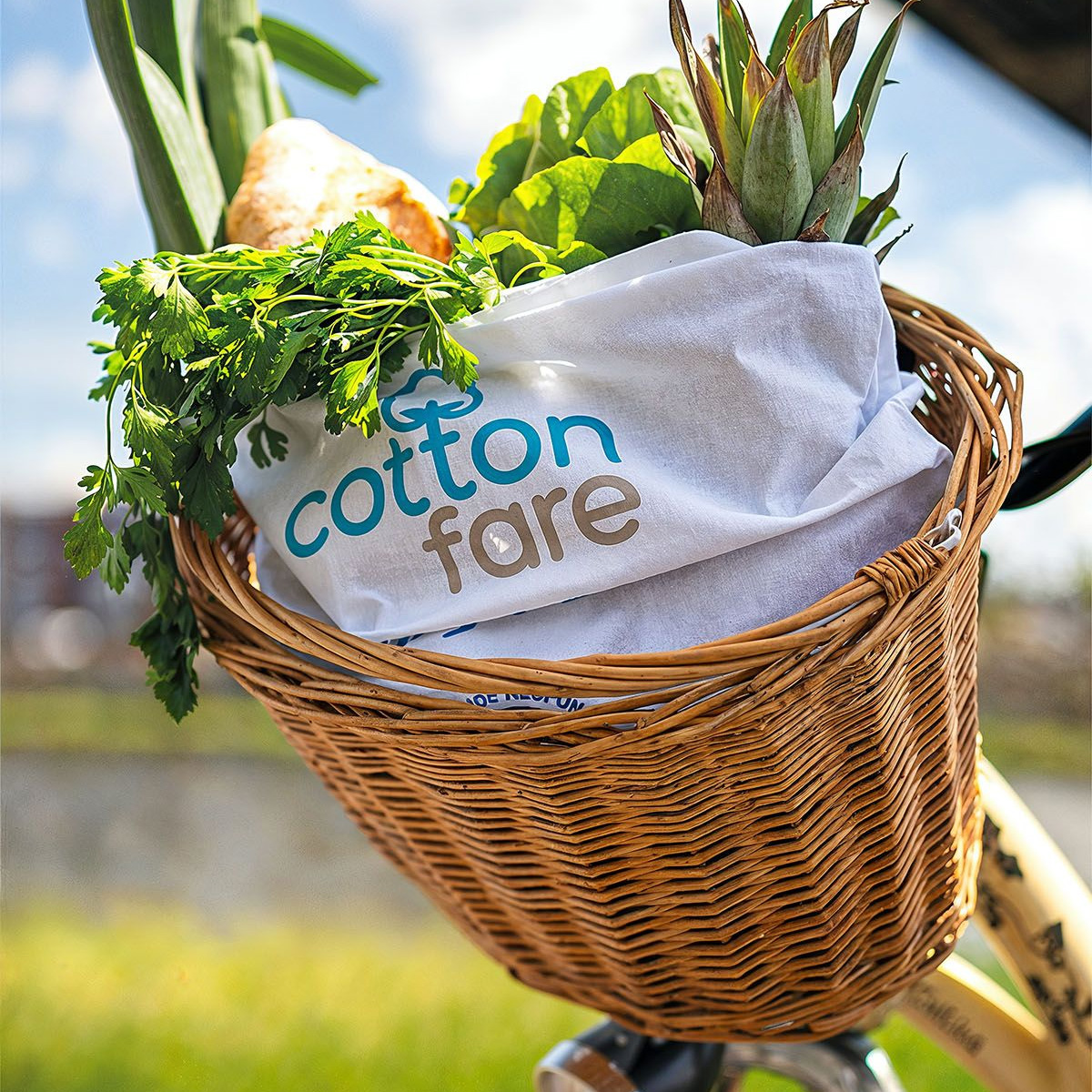 Torba Cotton Fare w kolorze białym w wiklinowym koszu na zakupy